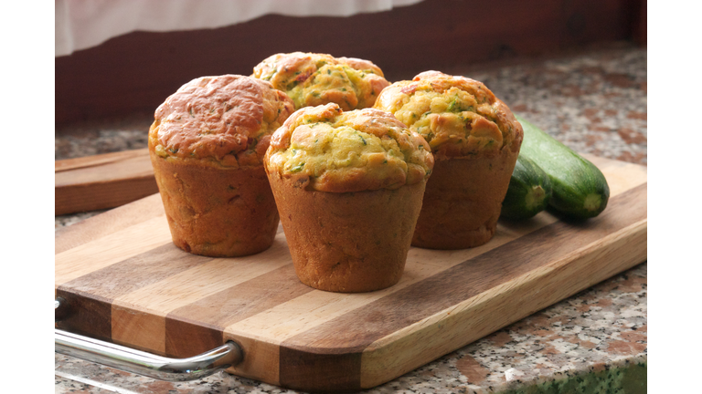 4 muffins made out of zucchini on a wooden board