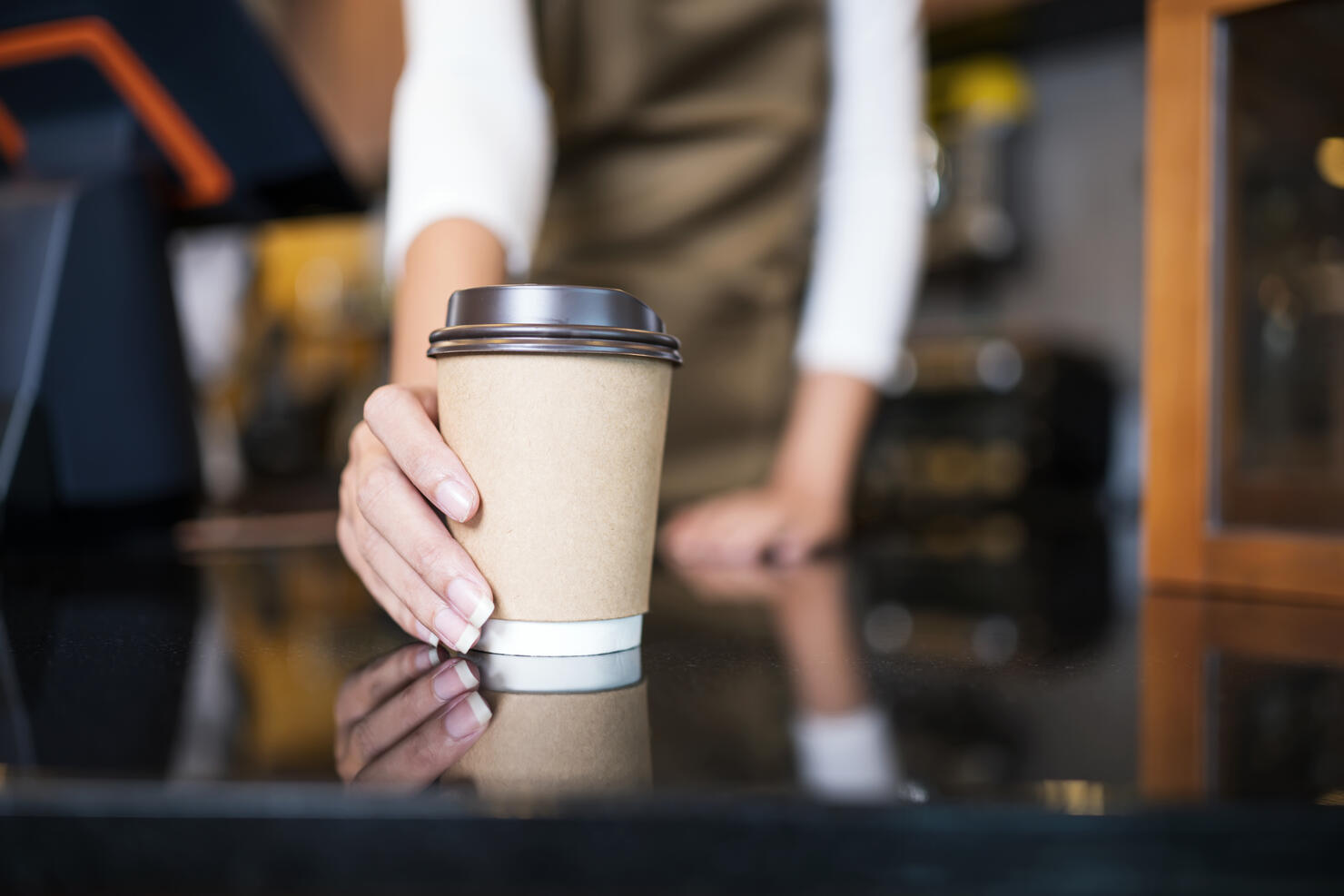 Please enjoy drinking a coffee. The unrecognizable waitress serving coffee to a customer in a cafe. Serving food and Drink, Point of Sale System.