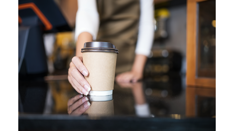 Please enjoy drinking a coffee. The unrecognizable waitress serving coffee to a customer in a cafe. Serving food and Drink, Point of Sale System.