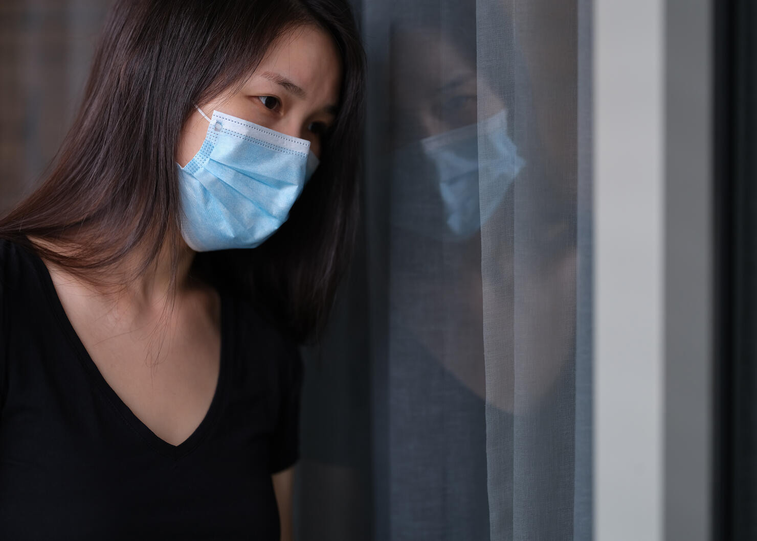 sad woman alone with surgical mask