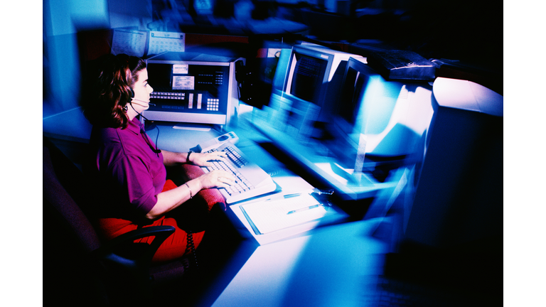 Woman working at police dispatch terminal