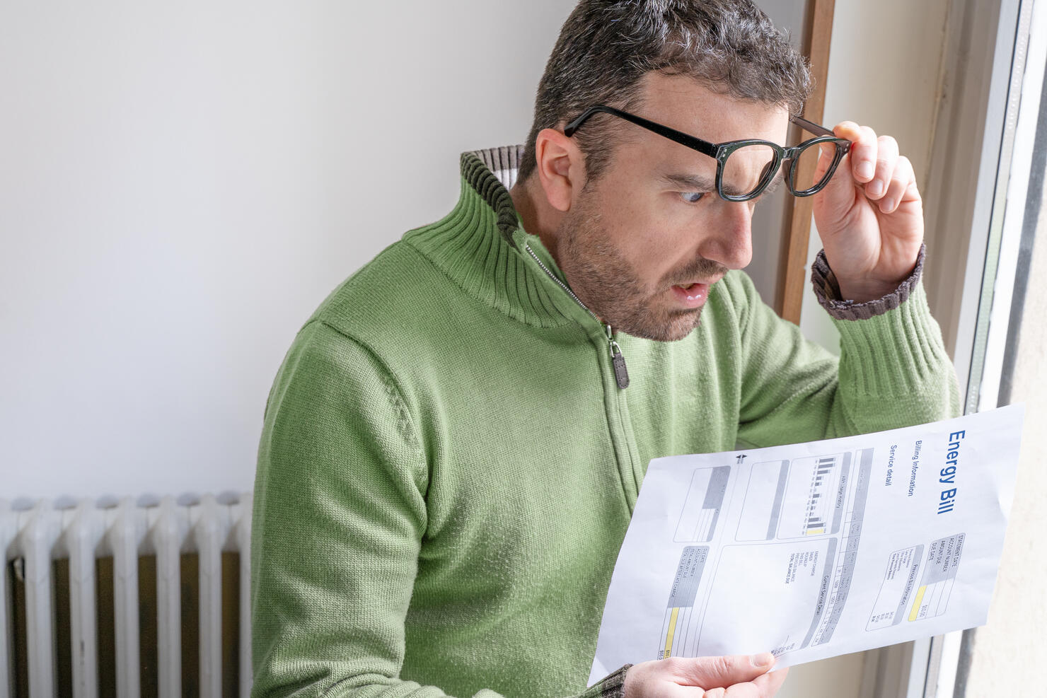 One man worried about bills reading energy increase costs
