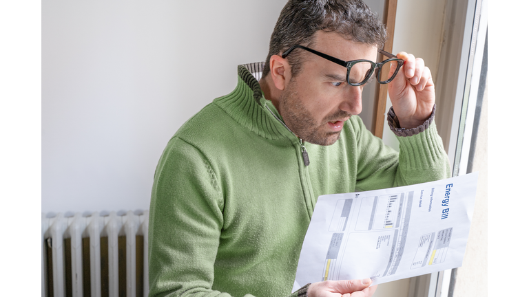 One man worried about bills reading energy increase costs