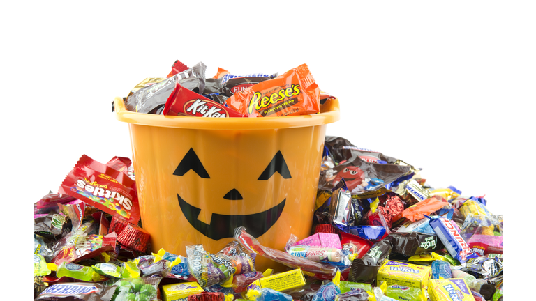 Orange plastic halloween bucket filled and overflowing with candy