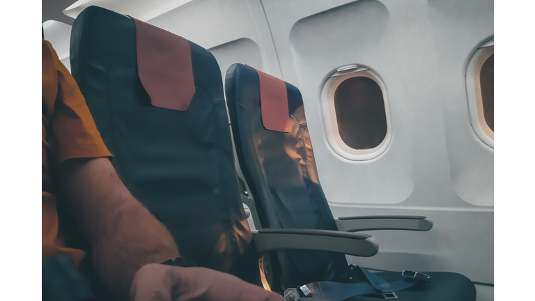 Midsection Of Man Sitting In Airplane
