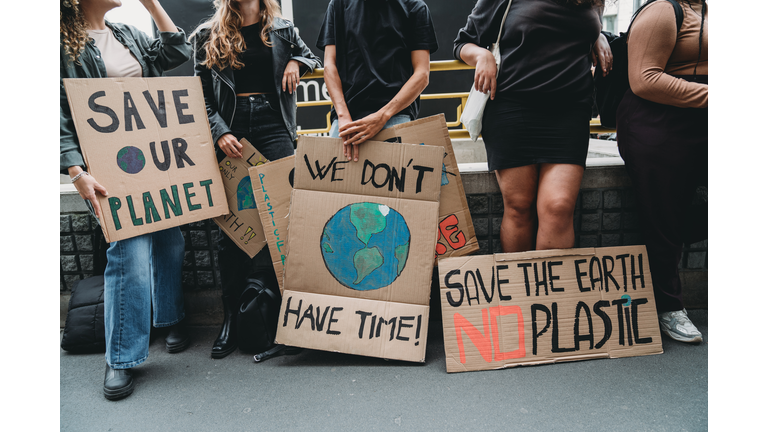 People are holding banner signs while they are going to a demonstration against climate change