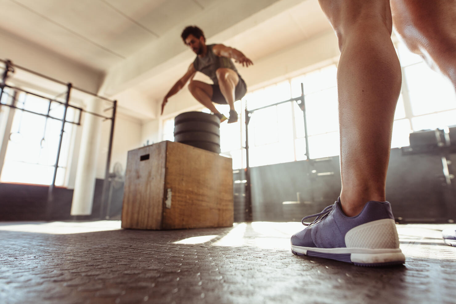 Fit man box jumping at cross training gym