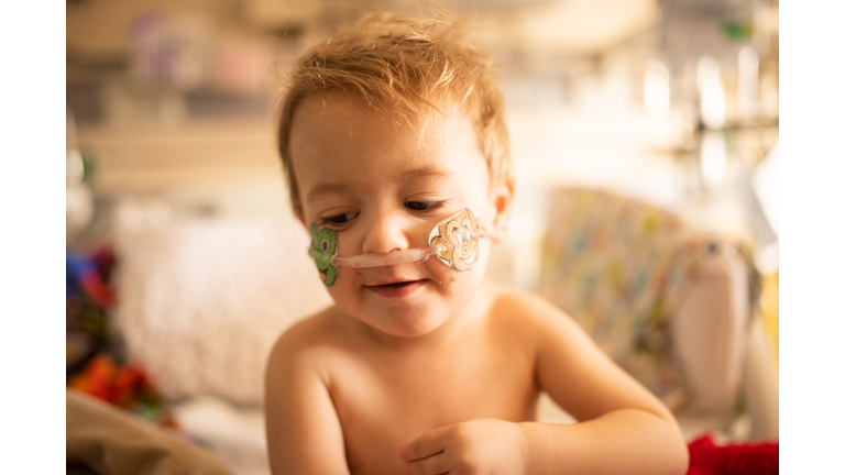 Two Year Old Toddler is Hospitalized in PICU for RSV and is seen with nasal canula and playing with toys.