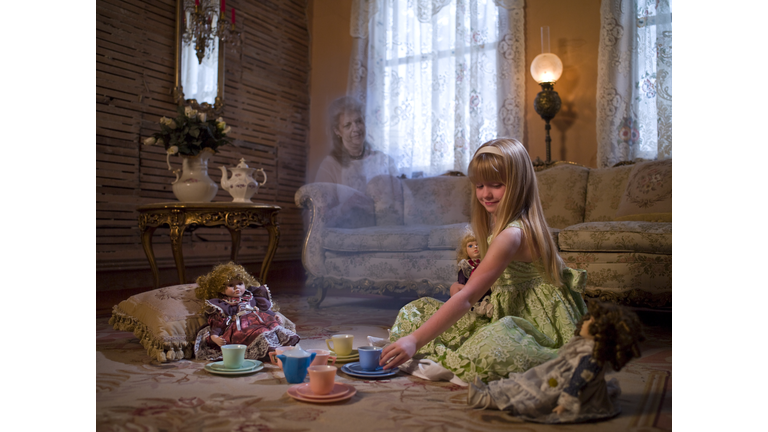 young girl having tea party with dolls