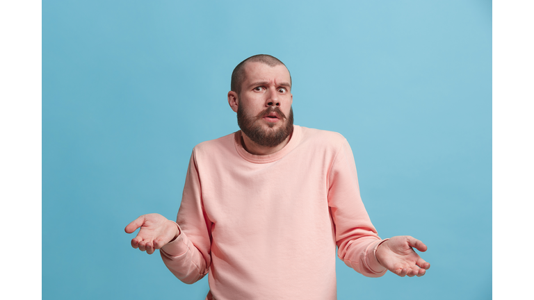 Beautiful man looking suprised and bewildered isolated on blue