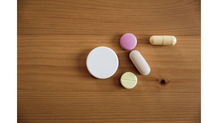 Various pills on a wooden table