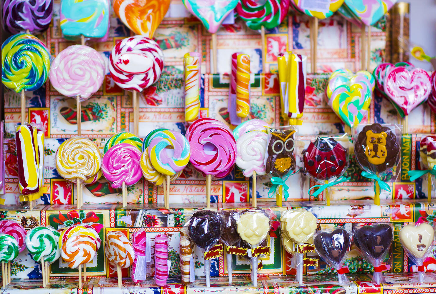 Great choice of colorful caramel on stick and chocolate candy for sale in shop window