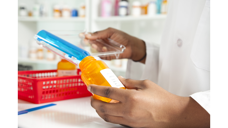 Pharmacist filling bottle for a prescription