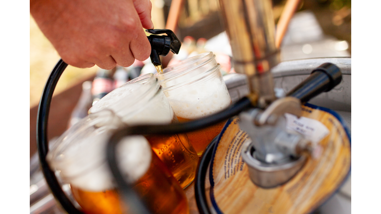 Beer being pourn into mason jar from keg