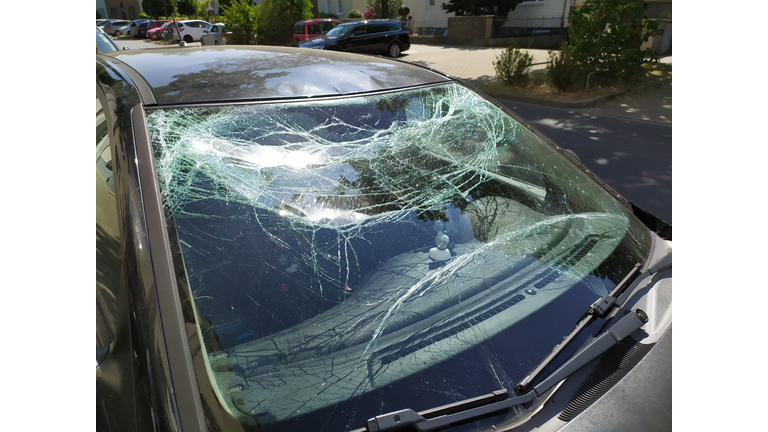Broken glass of the broken windshield after a heavy car accident ruined the windscreen and caused an injury that shattered and cracked the glass to show the need for car insurance damage insurance