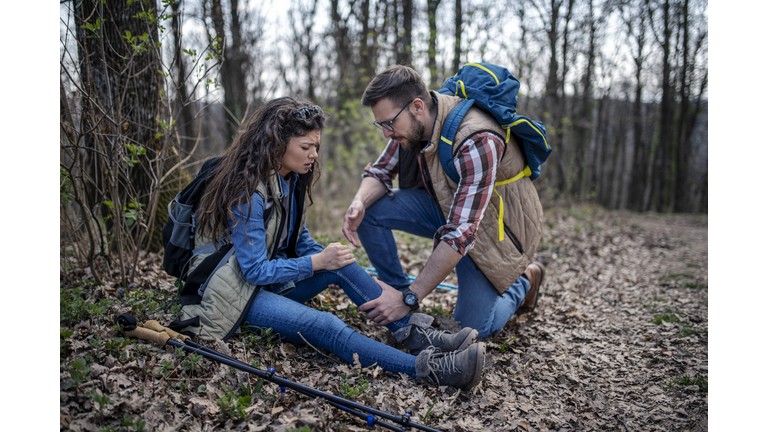 A woman has sprained her knee while hiking