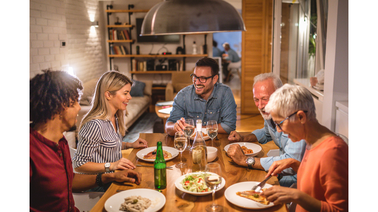 Group of close firends telling jokes and having fun at a dinner party