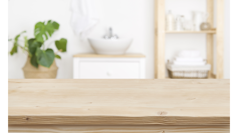 Empty wooden table top and blurred bathroom interior as background