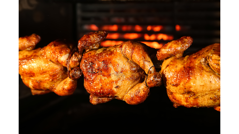 Grilling whole chickens in rotisserie machine, closeup