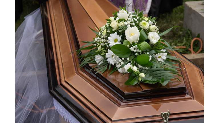 bouquet of white flowers on a coffin in the cemetery