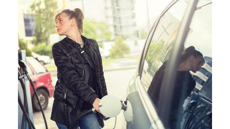 Young woman refueling her car