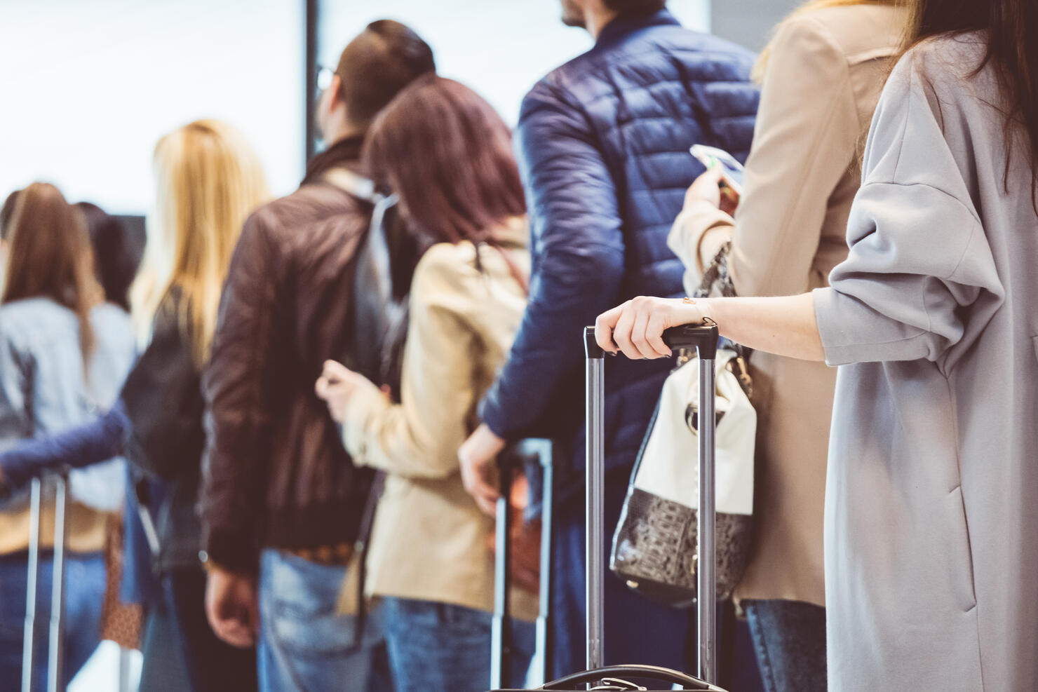 Group of people standing in queue at boarding gate