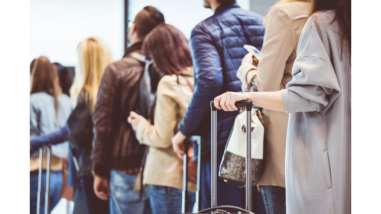 Group of people standing in queue at boarding gate