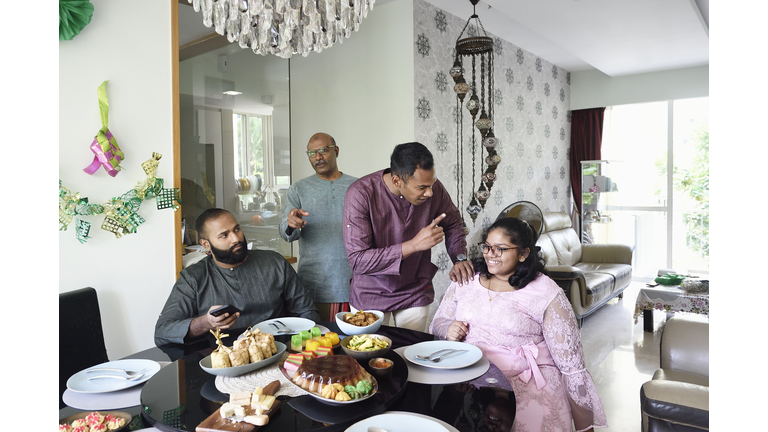 Family gathering around the dinner table for Hari Raya meal