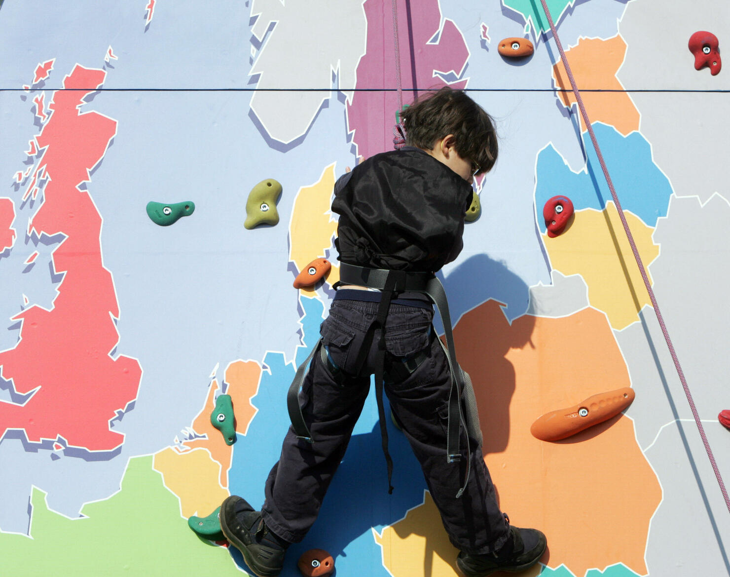 A child makes his way up a climbing wall...