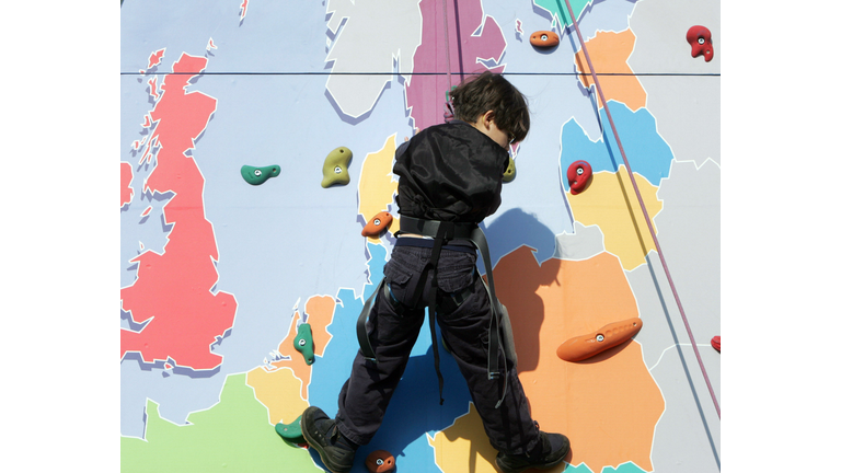 A child makes his way up a climbing wall...