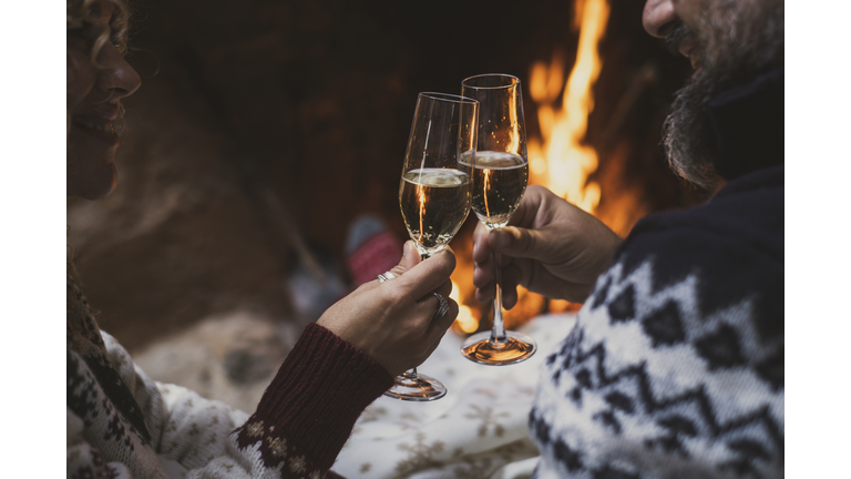 Midsection Of Couple Toasting Wineglasses