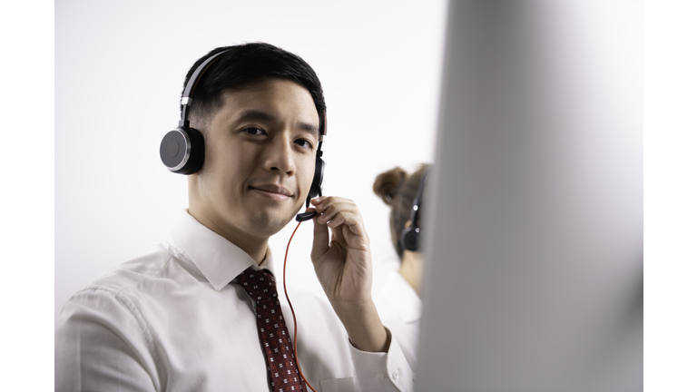 Asian call center operator in customer service department in office.