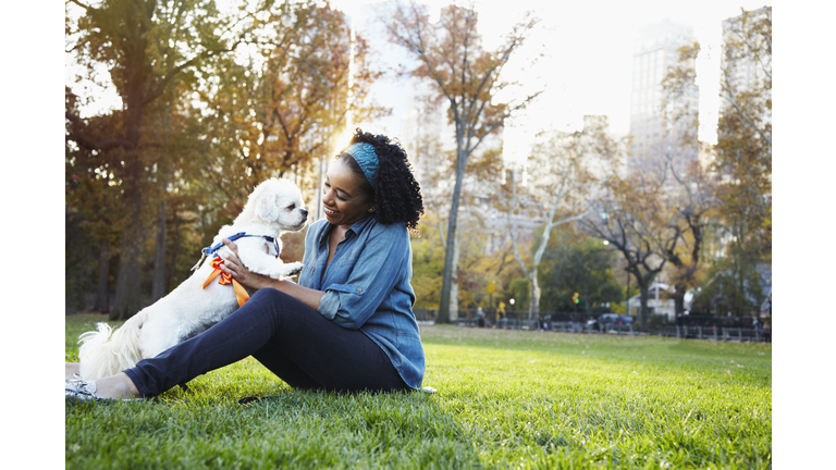 Woman holding dog in park