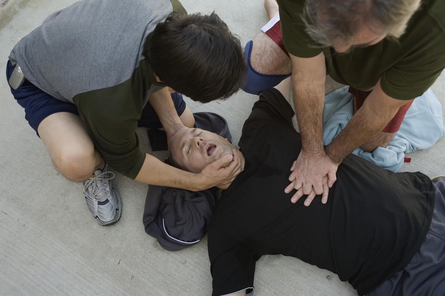 Men doing CPR on another man