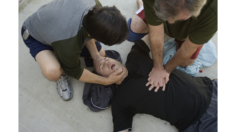 Men doing CPR on another man
