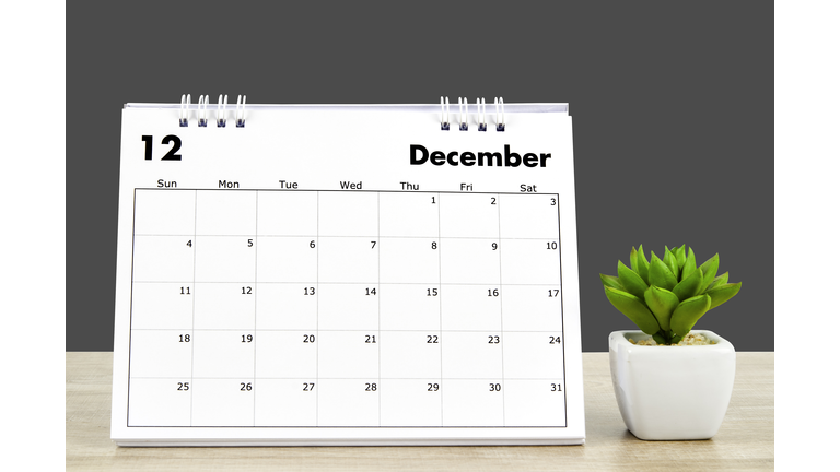 Calendar desk 2022 December month, Calendar planning and houseplant on wooden table with dark gray background, clipping path.