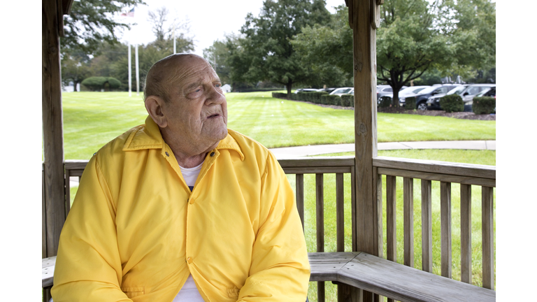 Super senior sitting outdoors contemplating