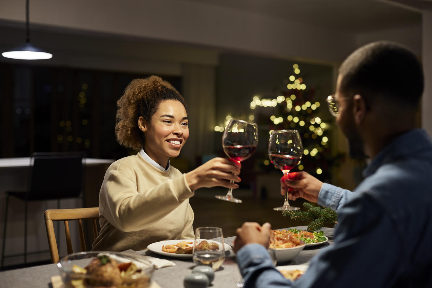 Couple Toasting Red Wine While Enjoying Dinner