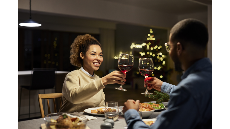 Couple Toasting Red Wine While Enjoying Dinner