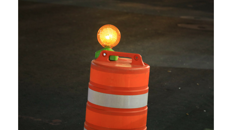 Orange reflective construction barrel with illuminated safety light