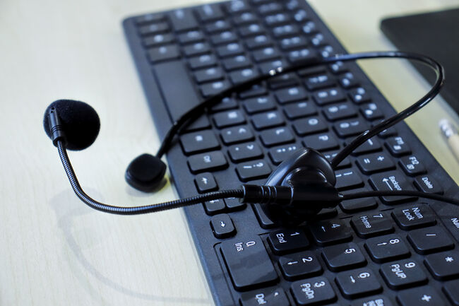 Communication support, call center and customer service help desk. headset on computer keyboard