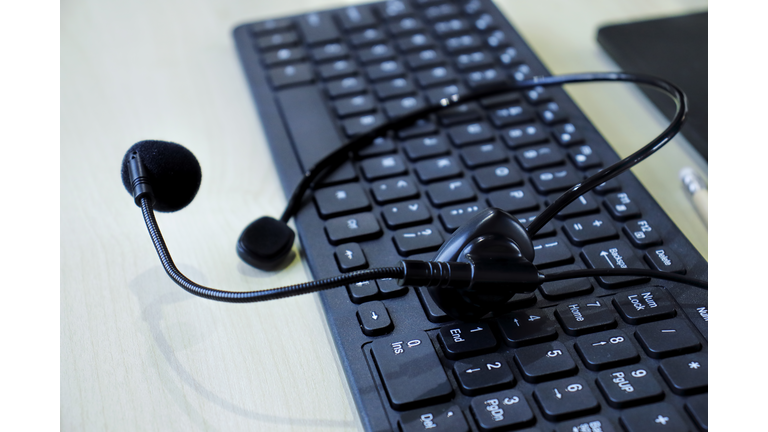 Communication support, call center and customer service help desk. headset on computer keyboard