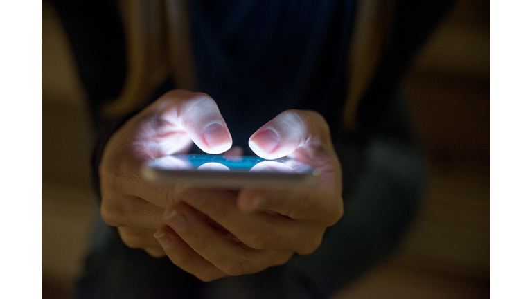 Female using her mobile phone outside at night