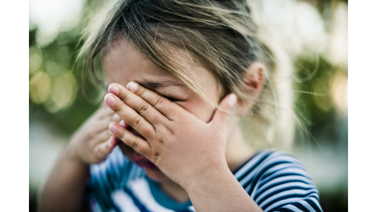 Young Girl Crying with Hands Covering Face