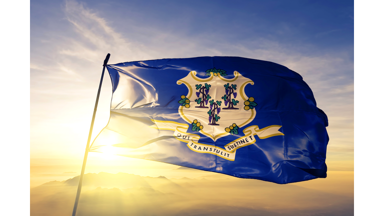 Connecticut state of United States flag textile cloth fabric waving on the top sunrise mist fog