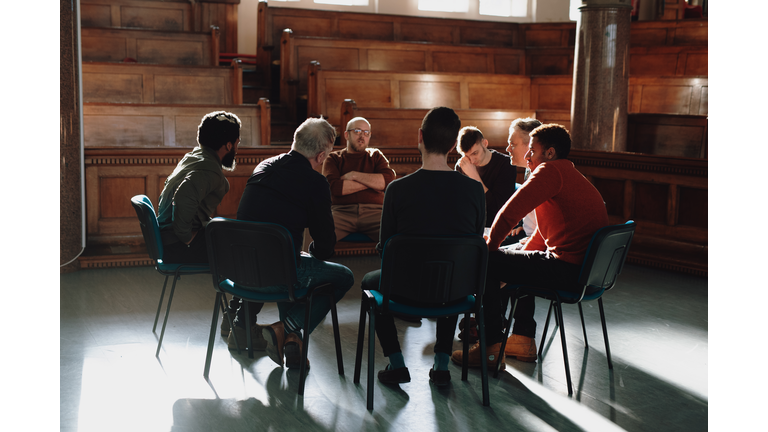 Group of men, seated in therapy session