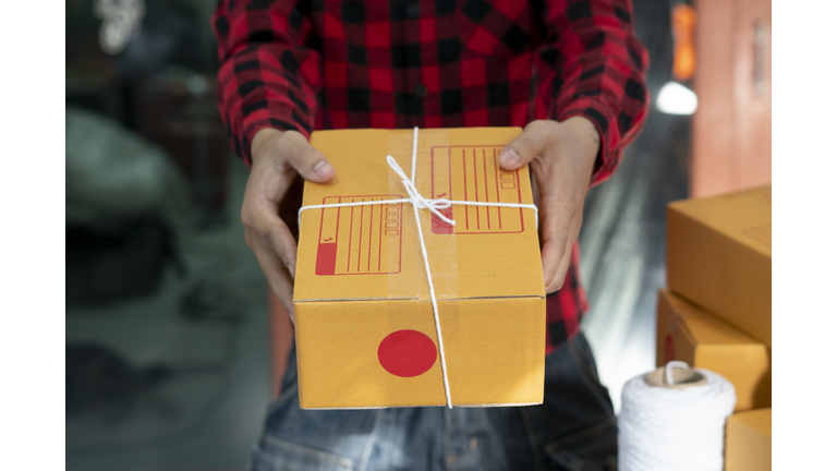 Woman hand accepting a delivery of boxes from deliveryman