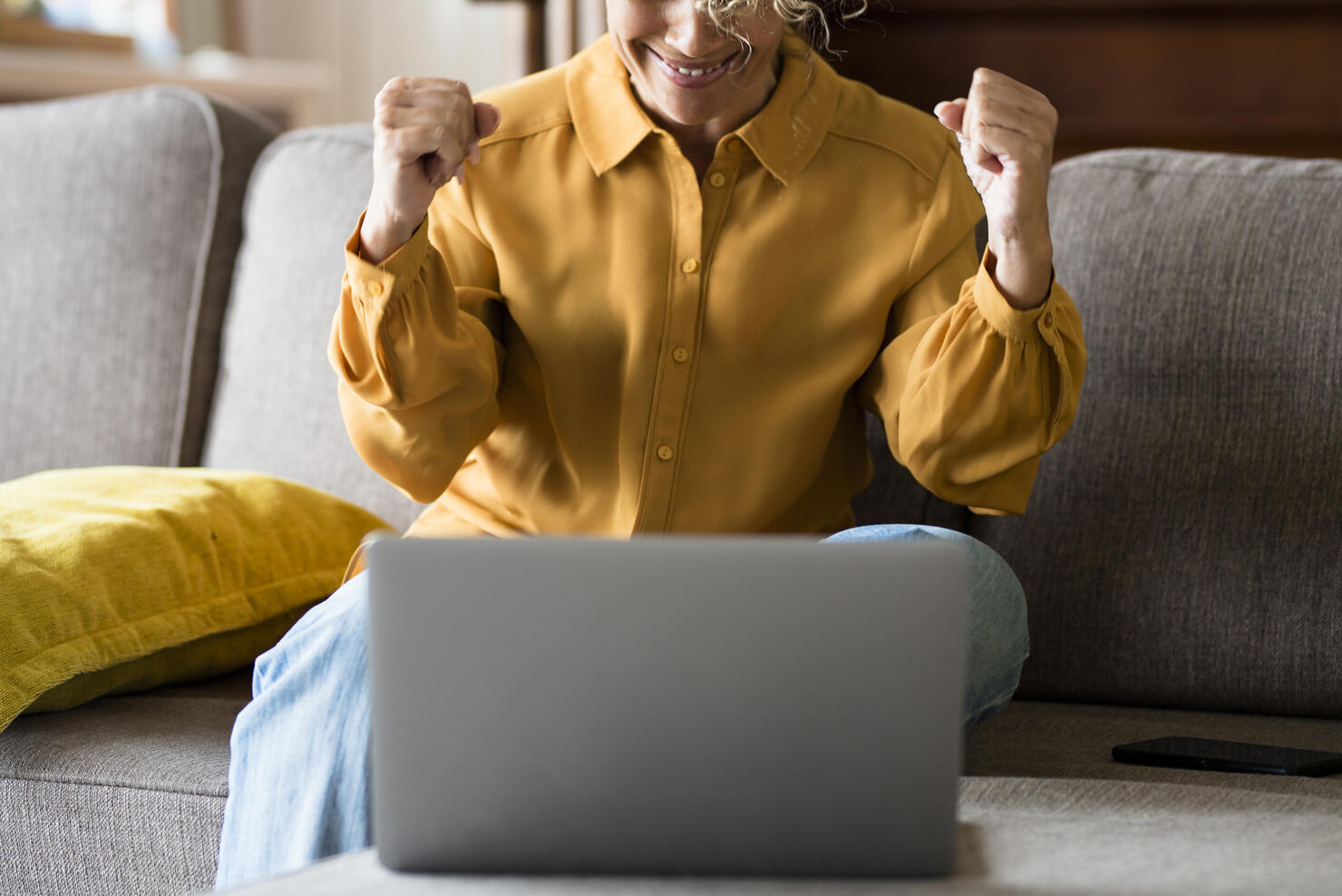 Midsection Of Man Using Mobile Phone While Sitting On Sofa At Home