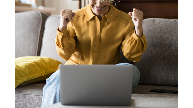 Midsection Of Man Using Mobile Phone While Sitting On Sofa At Home