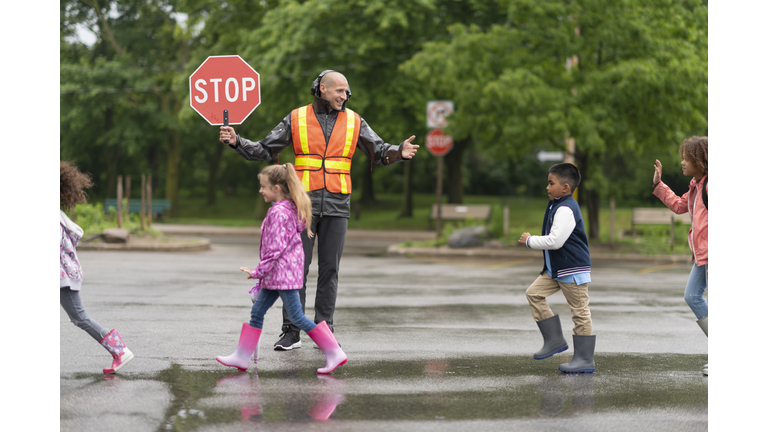 Elementary students cross street with help from crossing guard